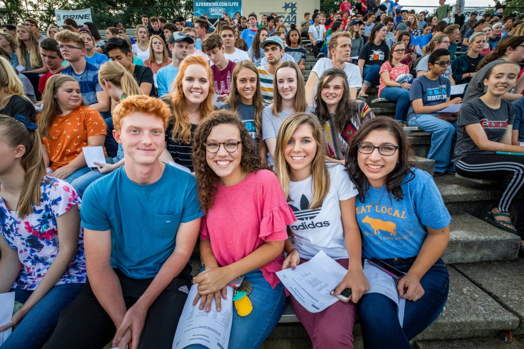 A group of students sitting in Alumni Stadium
