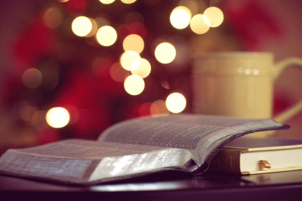 Bible and coffee mug with Christmas tree in the background