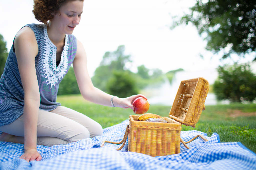 Girl reaches into a picnic basket