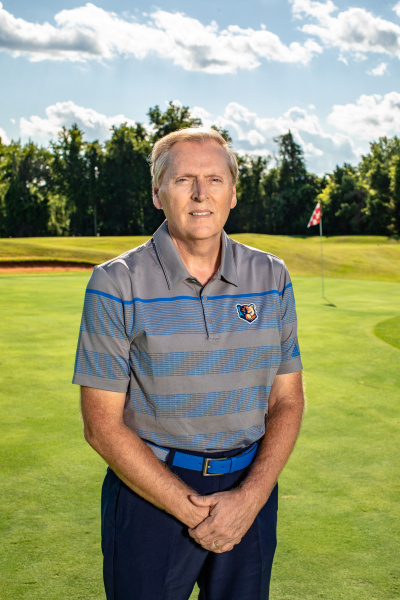 Portrait of Coach Denny on a golf course