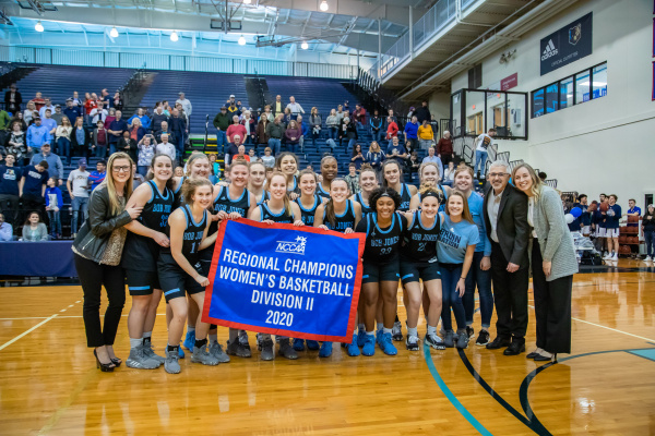 The Bruins women's basketball team with the championship flag