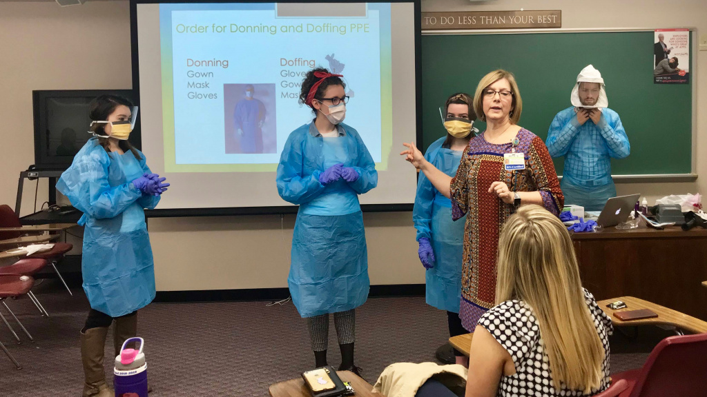 Beth Smith demonstrates PPE in Epidemiology class