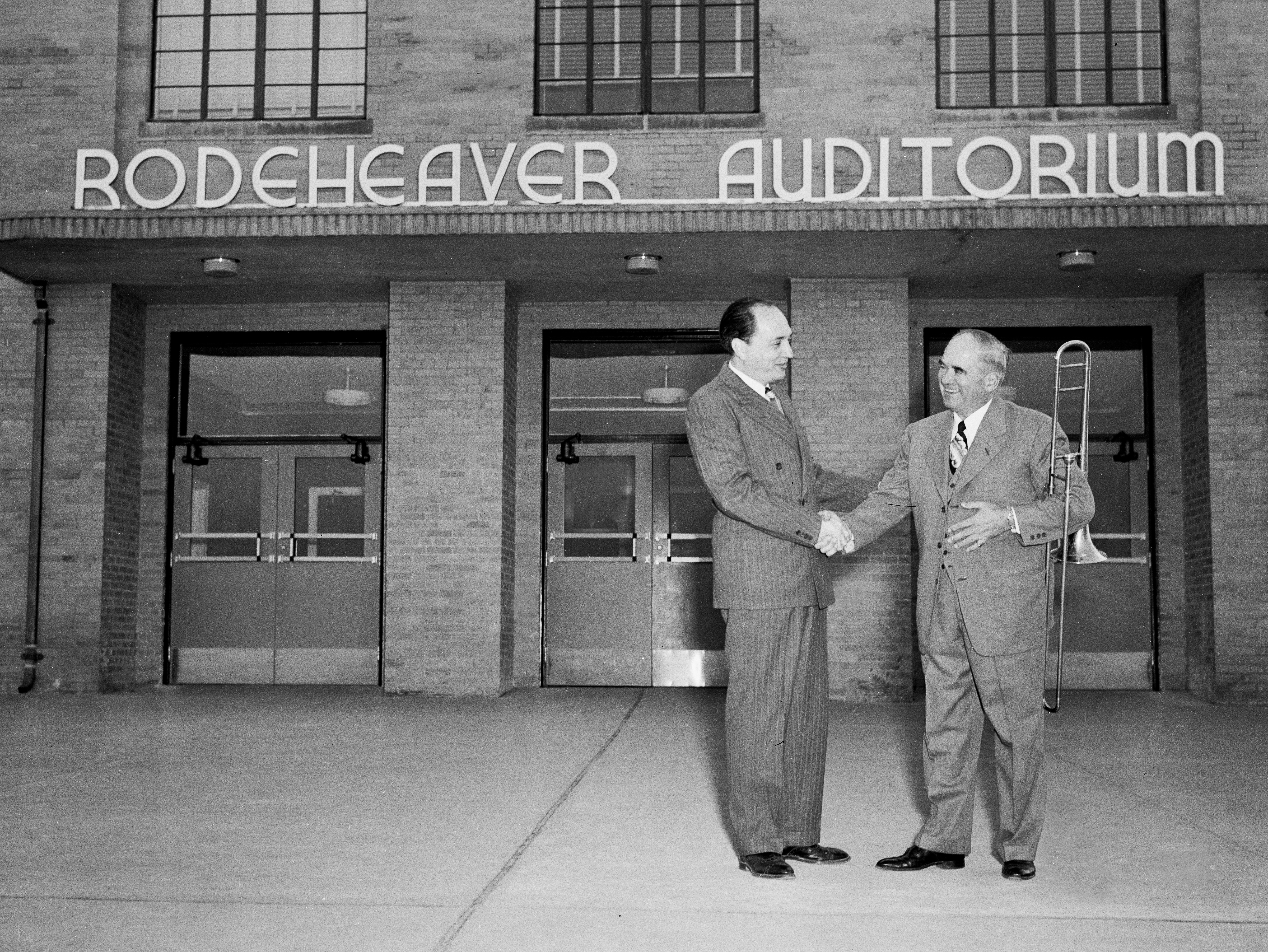 Dr. Bob Jones Jr shakes Homer Rodeheaver's hand outside the front entrance of Rodeheaver Auditorium
