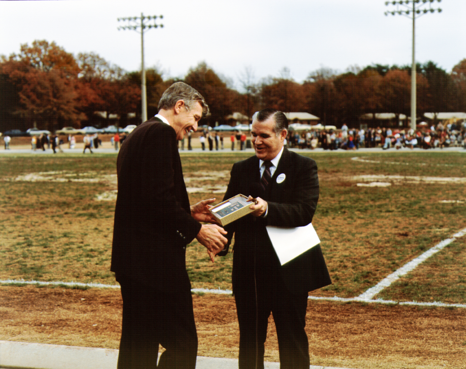 Photo of Dr. Bud Bierman giving Dr. Walter Fremont the Alumni Appreciation Award during halftime of the 1986 Turkey Bowl