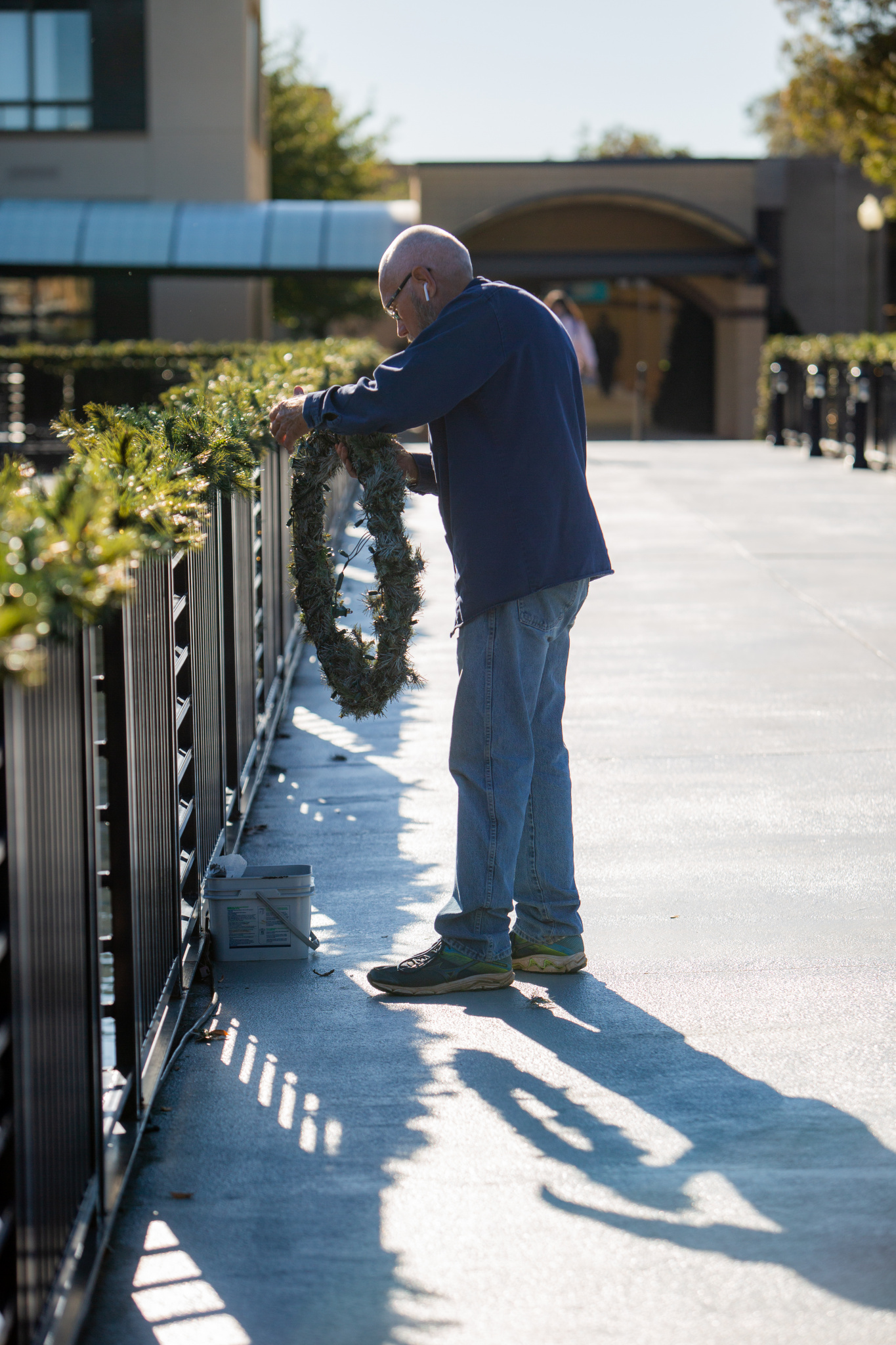 A grounds crew worker hangs one of many wreaths on the Bridge of Nations (Photo by Taylor Caldwell)
