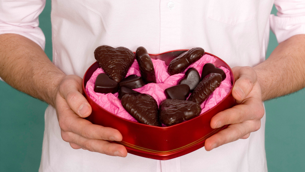 man holding heart shaped box of chocolates for Valentine's Day