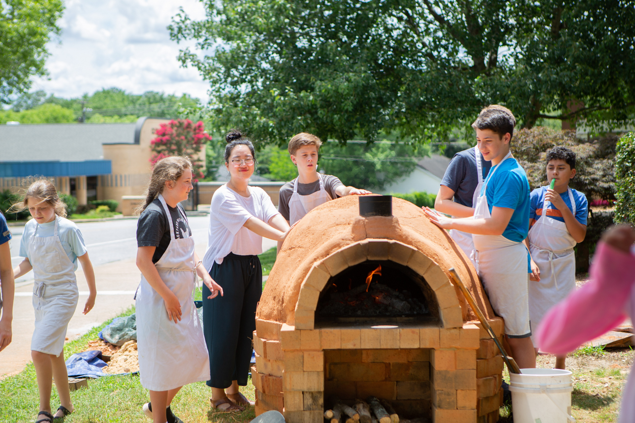 Middle school EDUcampers bake their doughs in the brick oven they helped construct
