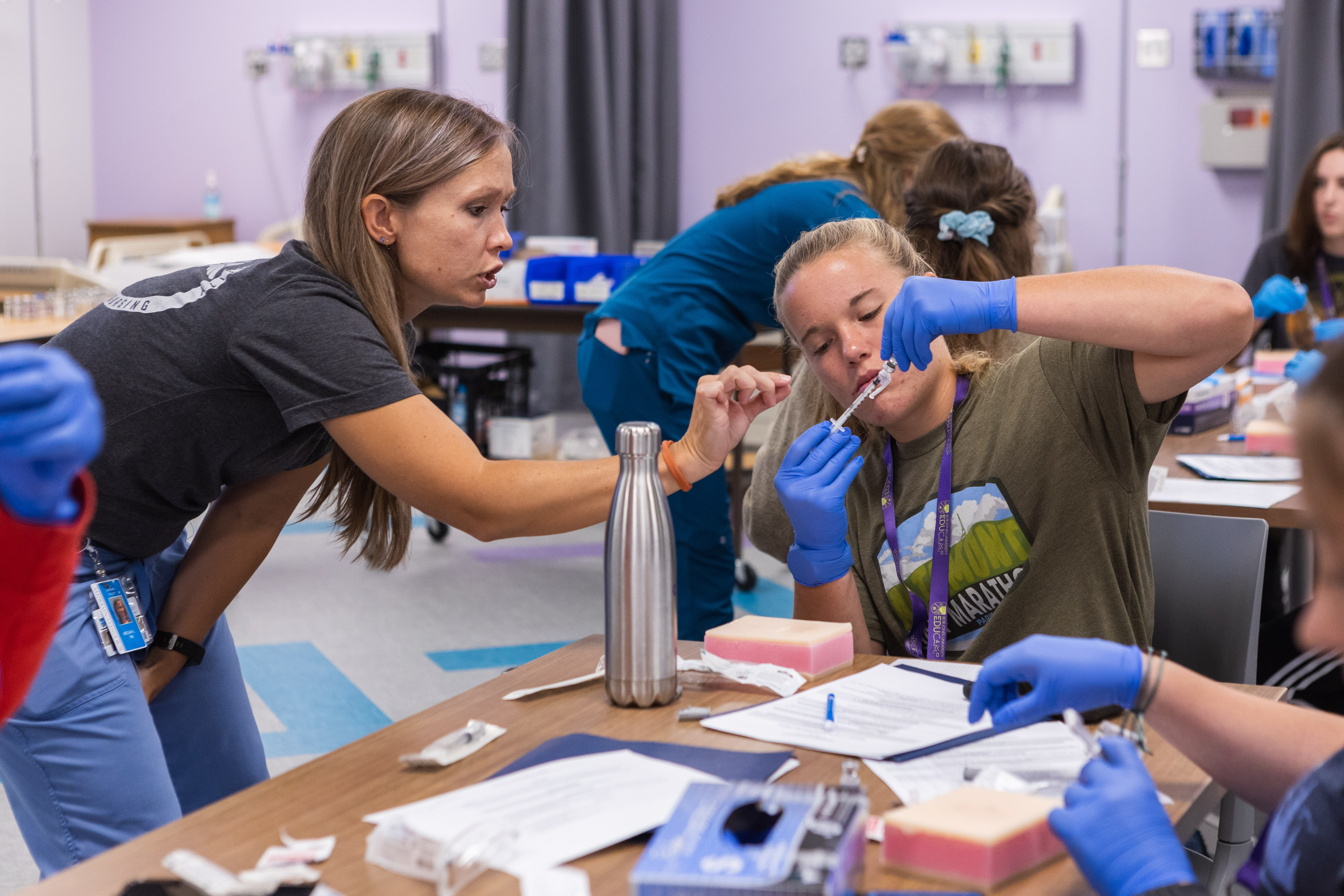 Campers attending the nursing EDUcamp learn how to administer shots from Division of Nursing chair Megan Lanpher